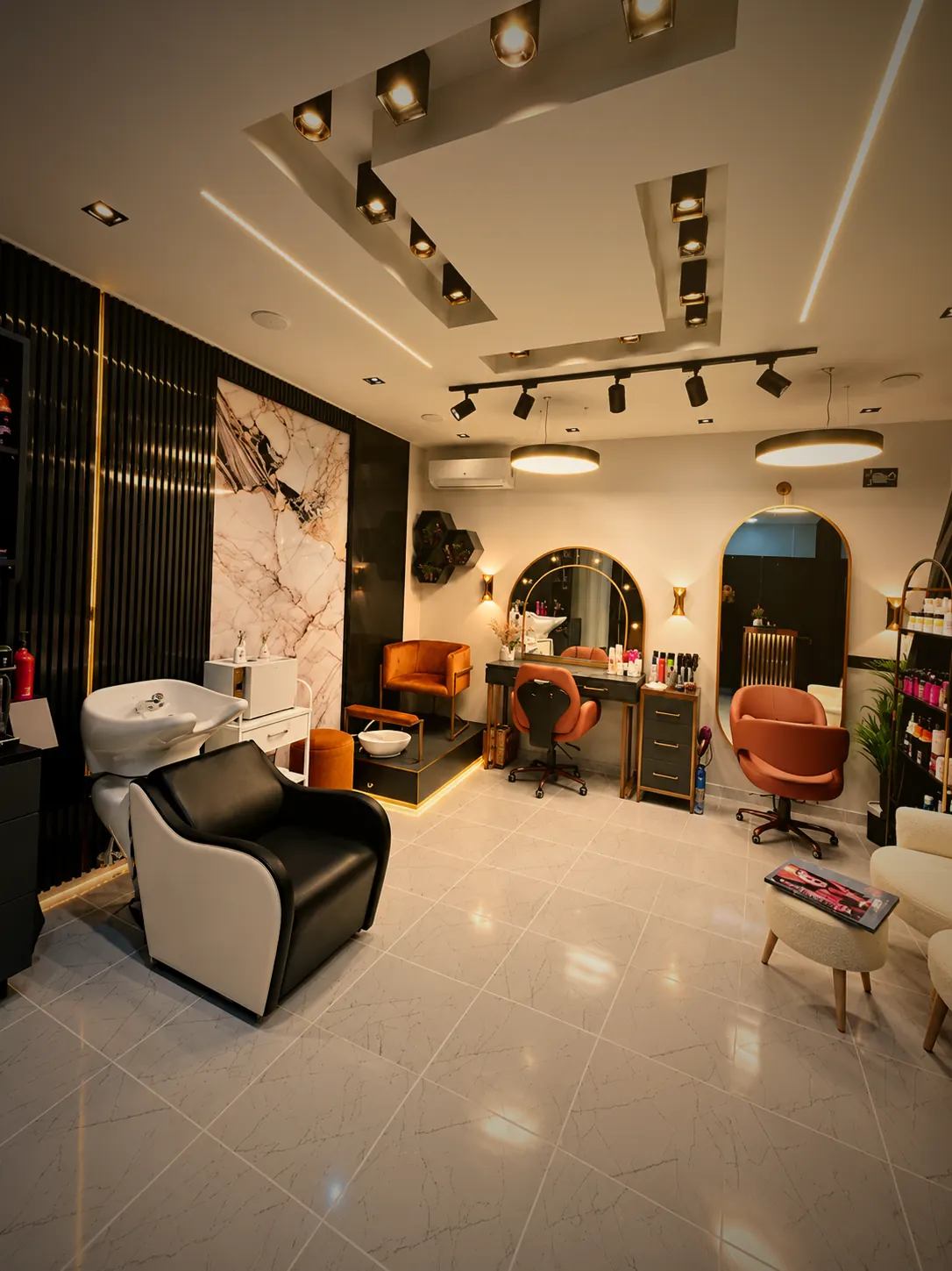 Makas Hair Studio Güzelbahçe salon içi: kemerli ışıklı aynalar, kuaför koltukları ve mermer duvar